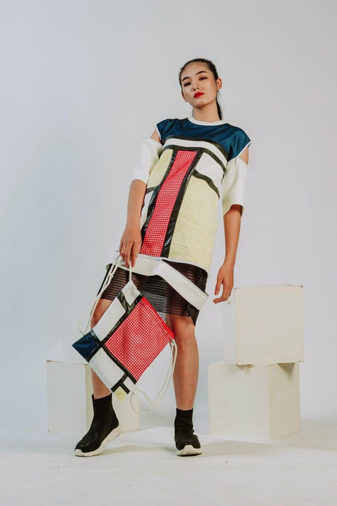 Woman wearing geometric print outfit standing in front of a white backdrop